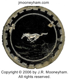 Remnant of an original Ford Mustang emblem from behind the small quarter windows of a 1969 Mustang