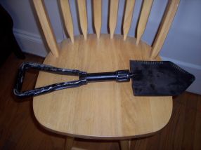 Photo of original black folding shovel accessory from a real life super car (in unfolded position).